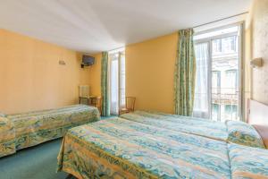 a hotel room with two beds and a window at Hotel Acapulco in Lourdes