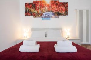 a bedroom with a large bed with two white chairs at 45 - Tourist House Bologna Oberdan - Self check-in in Bologna
