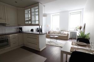 cocina con armarios blancos y sala de estar. en 2ndhomes Cozy 44m2 1BR home with best location in Kamppi! en Helsinki