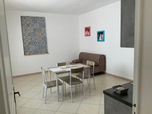 a table and chairs in a living room with a couch at La Gambetta in Uggiano la Chiesa