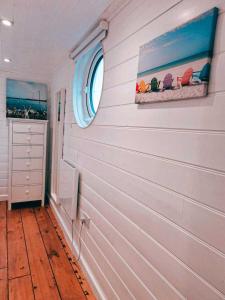 um quarto com uma parede branca com uma janela e cadeiras em The Pod em Kingsbridge
