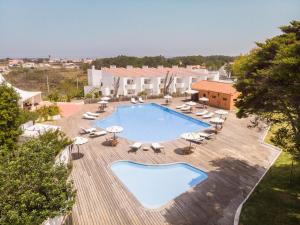 an overhead view of a swimming pool with chairs and umbrellas at Hotel Vale Da Telha in Aljezur