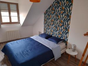 een slaapkamer met een bed met een blauw dekbed bij Appartement moderne et spacieux in Sedan