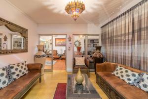 a living room with couches and a chandelier at Hotel Vale Da Telha in Aljezur