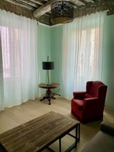 a living room with a red chair and a table at La Chicca del Centro in La Spezia +10 photos