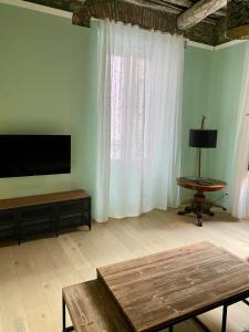 a living room with a flat screen tv and a table at La Chicca del Centro in La Spezia