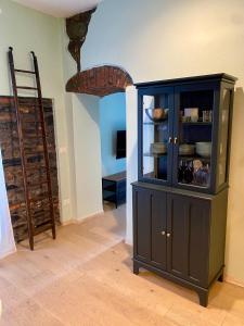 a black cabinet in a room with a ladder at La Chicca del Centro in La Spezia