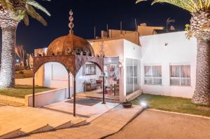a house with an archway in front of a building at Hotel Vale Da Telha in Aljezur