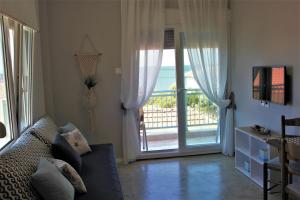 a living room with a couch and a sliding glass door at House Fedra in Potos