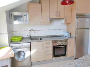 a small kitchen with a sink and a dishwasher at Ático Cool Isla de Arousa in Isla de Arosa