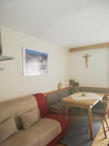 sala de estar con sofá y cruz en la pared en Apart Alpinea, en Landeck