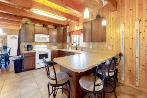 a kitchen with wooden cabinets and a island with bar stools at Swaying Pines in Wilmington