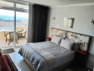 a bedroom with a bed with a view of the ocean at 2WhiteWaters Bloubergstrand Homestay in Bloubergstrand