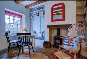 a living room with a table and a fireplace at The Old Crab Shop. PERFECT location & sea views. in Cromer