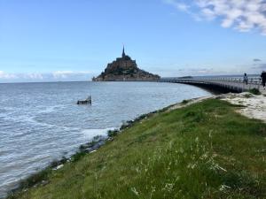 a bridge over the water with an island in the distance at Les2 cerisiers in Pontorson