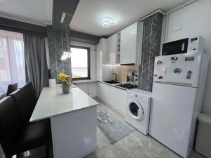 ママイアにあるBari Luxury Residence Mamaiaのキッチン(白い冷蔵庫、洗濯機、乾燥機付)