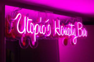 a neon sign that says dancing bar in pink at UTOPIC Campos Elíseos by ULIV in Mexico City