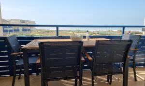 a table and chairs on a balcony with a view at Lacanau, Résidence Bleu Marine, appartement 2e étage, exceptionnel car balcon face et vue océan avec piscine ! Et avec parking réservé in Lacanau-Océan