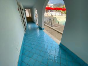 a hallway with blue tiled floors and a view of the beach at Ganimede Hotel in Sperlonga