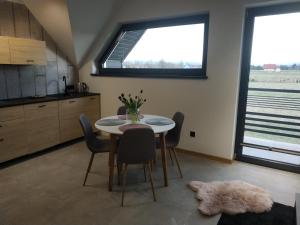 Un comedor con mesa y sillas y una ventana. en 285 Apartments, en Czarny Dunajec