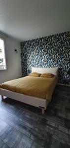 a bedroom with a bed with a blue and white wall at OISEAU DE PARADIS - 7 Min des Parcs Walt Disney- Arrivée autonome-Parking et Wifi gratuit- Proche commerces et restaurant Idéal pour les familles in Magny-le-Hongre