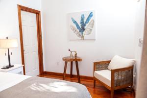 a bedroom with a bed and a chair and a table at Angeli Gardens Boutique Hotel in San Pedro Sula