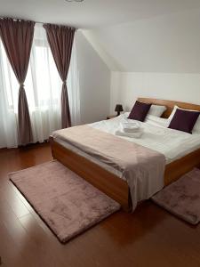 a bedroom with a large bed with white sheets at Casa Hoinarilor Wanderers House in Bran +32 photos