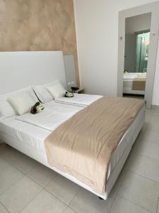 a bedroom with a large white bed with two birds on it at Hotel Bahia in Caorle