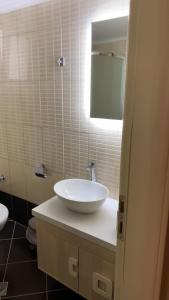 a bathroom with a white sink and a mirror at Theasis apartment in Pera Gyalos