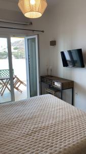 a bedroom with a bed and a desk and a television at Theasis apartment in Pera Gyalos