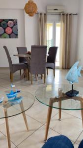 a living room with a glass table and chairs at Theasis apartment in Pera Gyalos