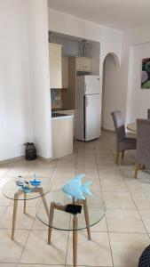 a living room with a table and a kitchen at Theasis apartment in Pera Gyalos +1 photo