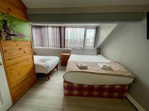 a small room with two beds and a window at Topaz Blackpool in Blackpool