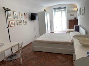 a small bedroom with a bed and a table at LIGURIA HOLIDAYS - "Monolocale di Charme" in Camogli