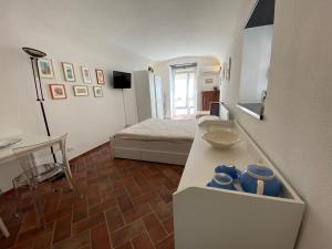 a room with a bed and a table with blue mugs at LIGURIA HOLIDAYS - "Monolocale di Charme" in Camogli