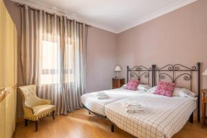 um quarto com uma cama, uma cadeira e uma janela em Flat Meridiana em Barcelona