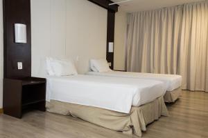 מיטה או מיטות בחדר ב-Master Express Moinhos de Vento