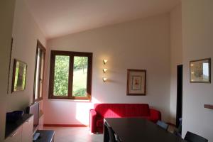 sala de estar con sofá rojo y ventana en Villino con piscina en Terni