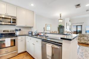 uma cozinha com armários brancos e electrodomésticos de aço inoxidável em Windswept 4309 em Kiawah Island