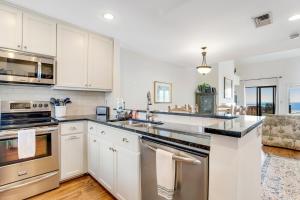 a kitchen with white cabinets and stainless steel appliances at Windswept 4309 in Kiawah Island