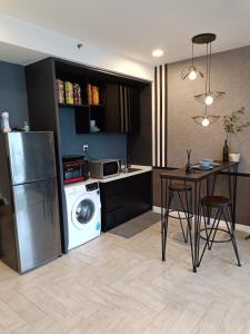 a kitchen with a washing machine and a table with chairs at Loft Signature Executive Suite Empire City in Petaling Jaya