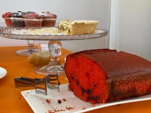 a piece of red velvet cake on a table with cupcakes at Ganimede Hotel in Sperlonga