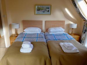 two beds in a bedroom with towels on them at Tornacraig 8 Person Country House on Royal Deeside in Aboyne