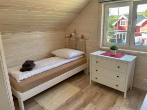 a small room with a bed and a night stand at Czerwone Domki in Dębki +21 photos