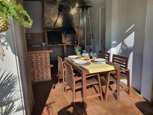 uma sala de jantar com uma mesa de madeira e cadeiras em Guest House Ruceel Aroeira em Almada