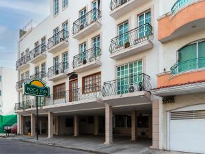 a large white building with balconies and a sign at Boca Inn Hotel & Suites in Veracruz