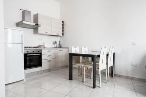 a kitchen with a black table and white appliances at Sinis Holiday House in Oristano