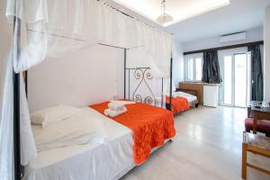 a bedroom with a bed with an orange blanket at Hotel Lodos in Karterados