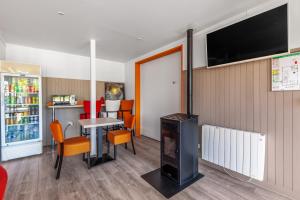 a room with a table and chairs and a television at Premiere Classe Rennes Ouest - Le Rheu in Le Rheu