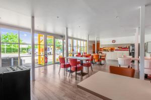 a restaurant with tables and chairs in a cafeteria at Premiere Classe Rennes Ouest - Le Rheu in Le Rheu